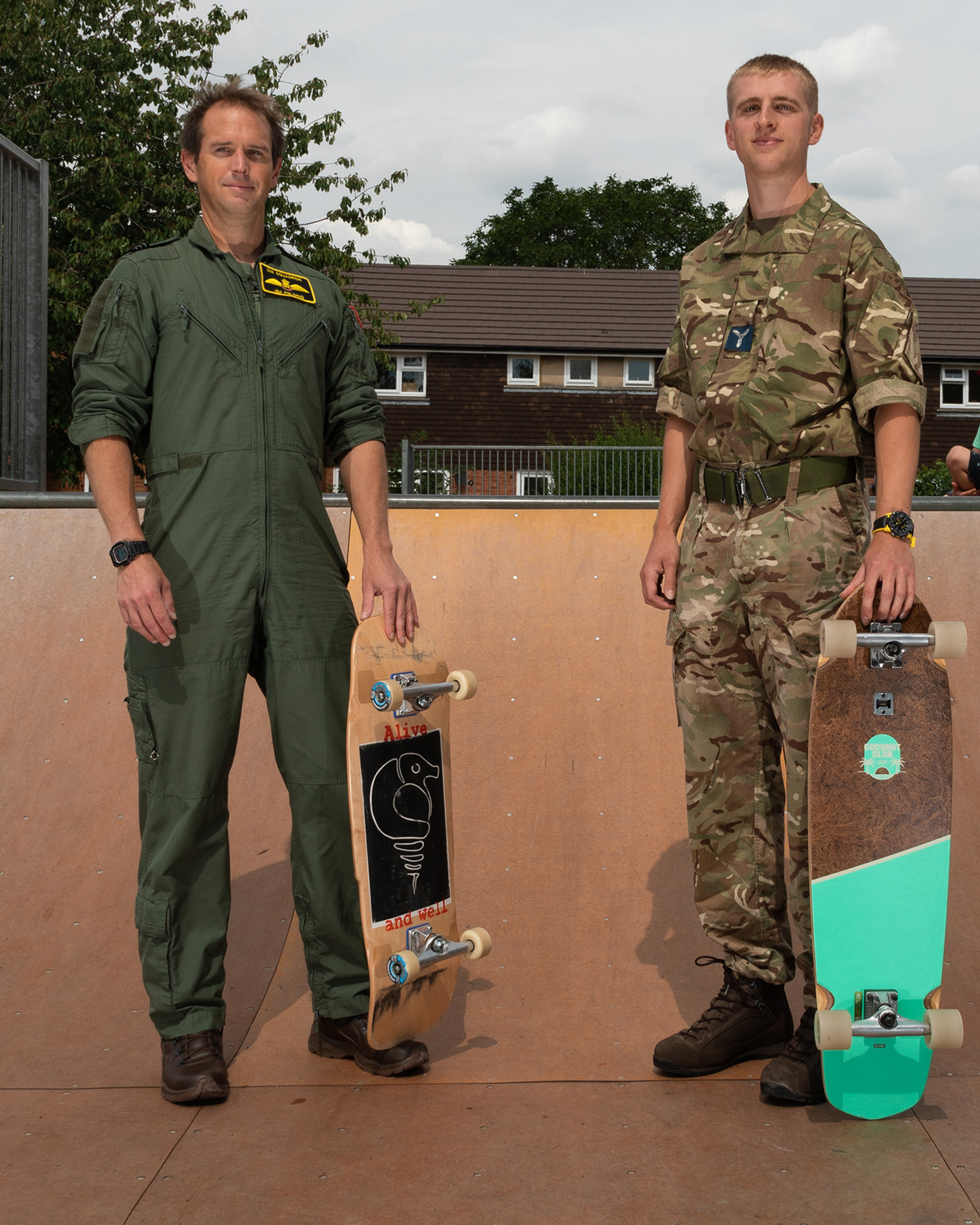 Image shows aviators in a skate park, standing with skate boards.